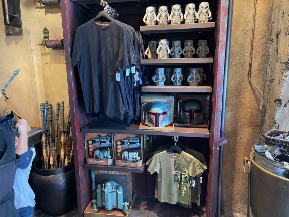 A display of new Star Wars Mandalorian merchandise in Galaxy's Edge at Disneyland featuring Boba Fett shirts and toys